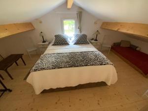 a bedroom with a large bed in a attic at Gite Wildflower Lane in Valojoulx