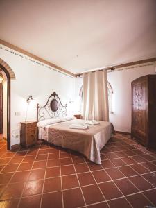 1 dormitorio con 1 cama y suelo de baldosa en Relais Casale Il Poggetto - OLIVO 1, en Cecina