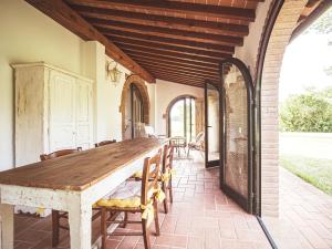 comedor al aire libre con mesa de madera y sillas en Relais Casale Il Poggetto - OLIVO 1 en Cecina