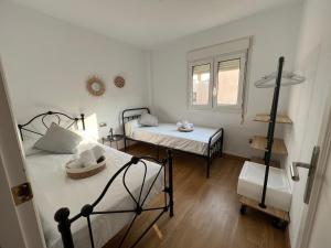 Habitación pequeña con 2 camas y ventana en La Pita en Almería