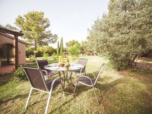 a table and four chairs sitting on the grass at Relais Casale Il Poggetto - OLIVO 1 by Zoom In Earth in Cecina