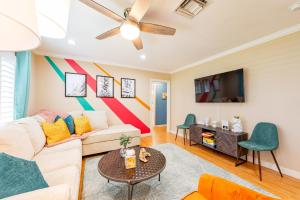 a living room with a couch and a tv at Colorful Home - Pool - Game Room - Basketball Court - BBQ & More in Fort Lauderdale