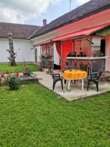 a patio with a table and chairs in a yard at T.I.M. in Bela Crkva