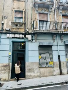 uma mulher à porta de um edifício em Loft buhardilla en perfecta ubicación em Santander
