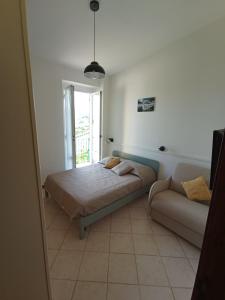 ein Schlafzimmer mit einem Bett und einem Sofa in der Unterkunft Al VIgneto in Sestri Levante