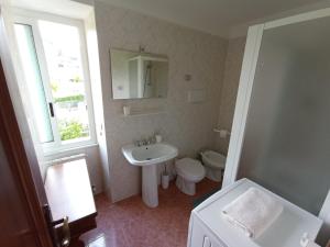 een badkamer met een wastafel, een toilet en een spiegel bij Al VIgneto in Sestri Levante