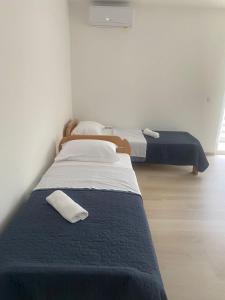 2 Betten in einem Zimmer mit weißen Wänden in der Unterkunft Apartmani Franciska in Jajce