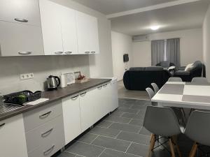 a kitchen with white cabinets and a living room at Apartmani Franciska in Jajce +40 photos
