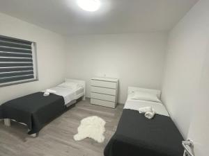 ein kleines Schlafzimmer mit 2 Betten und einer Kommode in der Unterkunft Apartmani Franciska in Jajce