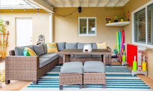 a patio with a couch and a table and chairs at Colorful Home - Pool - Game Room - Basketball Court - BBQ & More in Fort Lauderdale