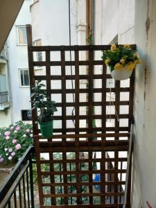 a chair on a balcony with two potted plants at SPiROS HOME in Preveza