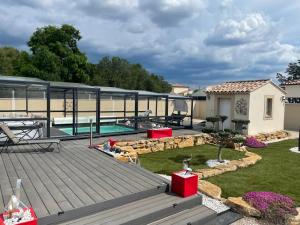 une arrière-cour avec une terrasse et une piscine dans l'établissement L'Aurore suite de charme, clim jacuzzi, sauna, piscine chauffée cuisine..., à Carpentras