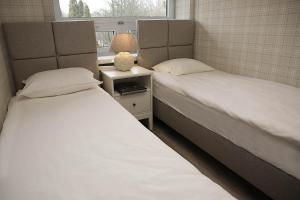 2 łóżka pojedyncze w pokoju z oknem w obiekcie Apartamenty nad Zalewem 213 w Serocku
