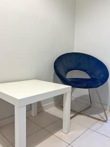 een blauwe stoel naast een witte tafel bij Mario's comfortable local apartment, next to metro station, close to Acropolis in Athene