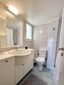 ein weißes Bad mit einem Waschbecken und einem WC in der Unterkunft Mario's comfortable local apartment, next to metro station, close to Acropolis in Athen