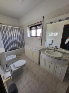 La salle de bains est pourvue de toilettes et d'un lavabo. dans l'établissement Margem Sul rooms, à Caparica