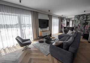 sala de estar con sofá y TV en Lazur Apartamenty Domki en Sarbinowo