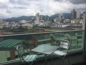 - Balcón con mesa y sillas y vistas a la ciudad en Exclusive Furnished Apartment 4, en Manizales