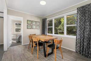 a dining room with a wooden table and chairs at The Greenkeeper's Cottage in Rotorua