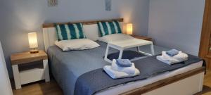 a bedroom with a bed with towels on it at Apartament Cumulus in Chojna