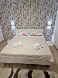 a bedroom with a bed with two towels on it at Apartments Julijana 2 in Privlaka +41 photos