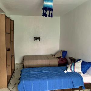 a bedroom with a bed with a blue blanket at house naim in Chefchaouen