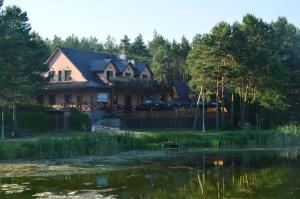 a house with a pond in front of it at Tawerna Nad Sopotem in Susiec
