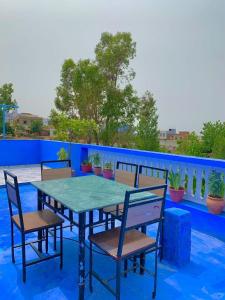 a table and chairs on top of a balcony at house naim in Chefchaouen