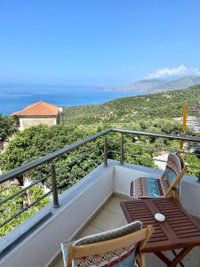 einen Balkon mit einem Tisch, 2 Stühlen und Meerblick in der Unterkunft Apartment for rent Piqeras, Sarande in Piqeras