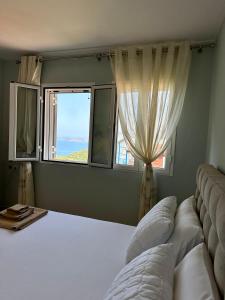 Un dormitorio con una cama grande y una ventana en Apartment for rent Piqeras, Sarande en Piqeras