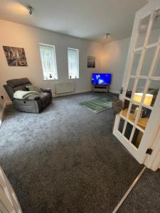 a living room with a couch and a tv at Washington Village Apartment in Washington