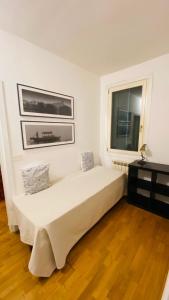 a white bedroom with a large bed and a window at San Maurizio Apartment in Venice