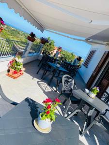 un patio con tavolo, sedie e fiori di B & B Vilenia San Nicola Arcella a San Nicola Arcella