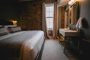 a bedroom with a bed and a sink and a window at Historic Jacksonville Inn in Jacksonville