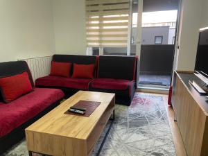 een woonkamer met twee rode banken en een salontafel bij Ellnur Bulevar in Sarajevo