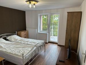 a bedroom with a bed and a television and a window at Apartamenty Oaza Spokoju in Sopot