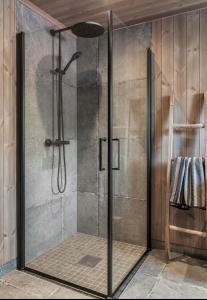 a shower with a glass door in a bathroom at Norebu - Norefjell in Noresund