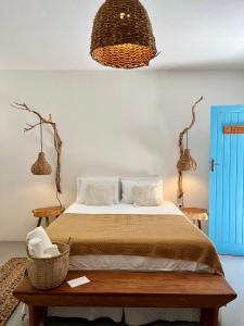 a bedroom with a bed and a blue door at Pousada Caraíva in Caraíva