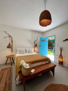 a bedroom with a bed and a blue door at Pousada Caraíva in Caraíva