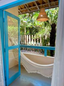 a porch with a hammock and a window at Pousada Caraíva in Caraíva