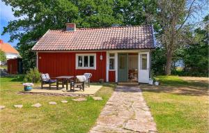 une petite maison rouge avec une table et des chaises dans l'établissement Amazing Home In Frjestaden With Kitchen, à Färjestaden
