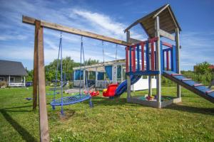 a playground with slides and swings in a yard at Terraced Houses, Rewal in Rewal