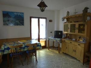 una camera con tavolo e una cucina con televisore di Casa Pederzolli - a Lagolo di Calavino