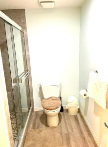 a bathroom with a toilet and a glass shower at Steven Abode in Calgary