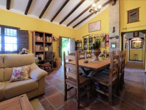 ein Wohnzimmer mit einem Tisch und einem Sofa in der Unterkunft Belvilla by OYO Casa AragÃ¼ez in Canillas de Aceituno
