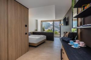een woonkamer met een bed en een bank bij Gardea SoulFamily Resort in Nago-Torbole