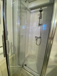 a shower with a glass door in a bathroom at Charming house close to the Plage des Huttes in Chaucre