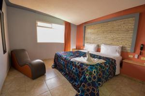 a hotel room with a bed and a chair at Motel Venecia in Momoxpan