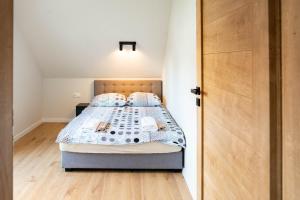 sypialnia z łóżkiem i drewnianą podłogą w obiekcie Ginger Apartament w mieście Wilkasy