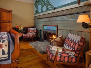 a living room with two chairs and a fireplace at Abbey's Lantern Hill Inn in Ledyard Center